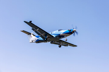 Fototapeta na wymiar Single-engine blue airplane flying on a sunny day in the blue sky. The plane rises after takeoff.