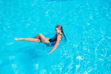 Little adorable girl in outdoor swimming pool