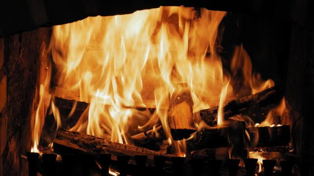 Close up shot of Burning Flame At Fireplace on wooden logs. Close-up shot of of a yule log burning in a fireplace.