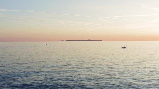 Aerial dolly shot backing away from Susak island in Croatia late in the day.