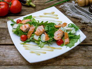 mixed salad with salmon on old wooden table