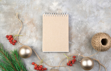 Christmas composition of Notepad, Christmas toys, retro camera and red viburnum on a gray background. Holiday background. The concept of the new year 2021 and Christmas.