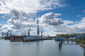 Fototapeta premium Harbor with large cranes and containers in Rotterdam, Holland