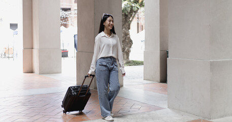 Asian woman beaming carrying a suitcase black to travel on vacation, Trolley bag, Long weekend travel, Love the trip, Tourism festival concept.