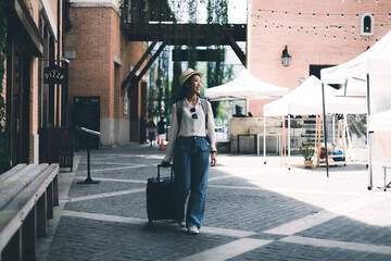 Asian woman beaming carrying a suitcase black to travel on vacation, Trolley bag, Long weekend...