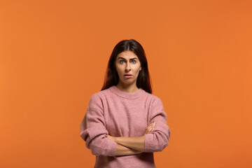 Irritated looks surprised. Portrait of serious woman in pink sweater, has serious confident...