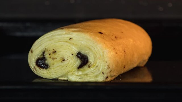 Close up of french chocolatine, pain au chocolat baking in oven 4K