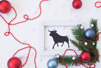 new year's white frame with fir branches and Christmas balls with the symbol of 2021 - bull, on a white background