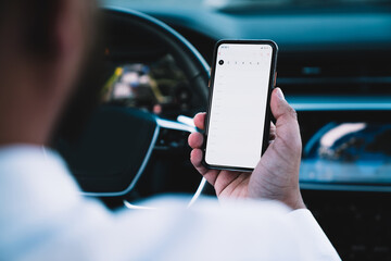 Crop man looking at screen of phone