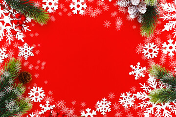 Christmas background with tree branches and snowflakes on red canvas background