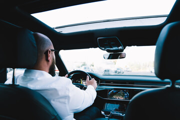 Focused faceless man driving car to work