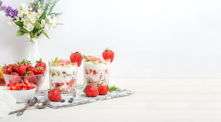 Muesli with yogurt and fresh strawberries on a white background with copy space