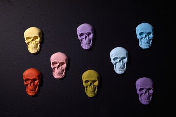 Rainbow color sculls on black background. Halloween flat background.