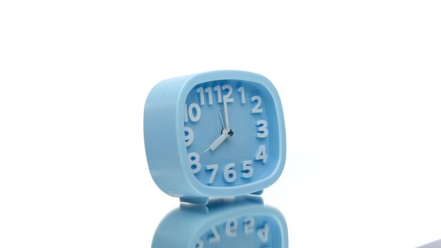 Blue square alarm clock showing eight o'clock spinning rotating 360 isolated on white background. Time starting work in morning. lucky hour concept.