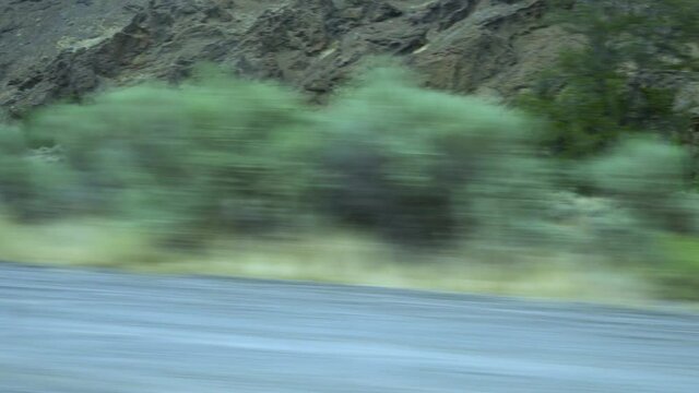 Passing the base of a mountain in the western part of the united states of America.