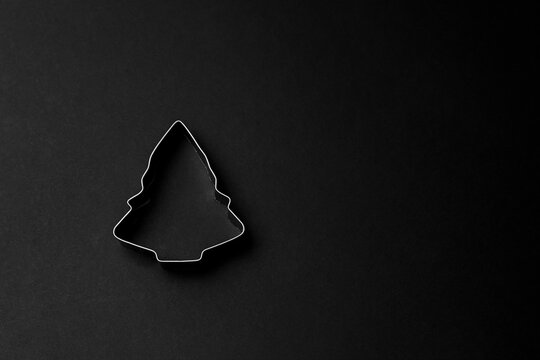 Christmas tree shape cookie cutter on black background