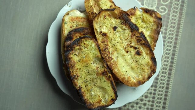 closeup of several slightly burnt garlic bread viewed from above
