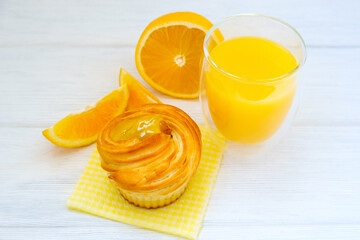Orange cake and orange juice on white wooden background