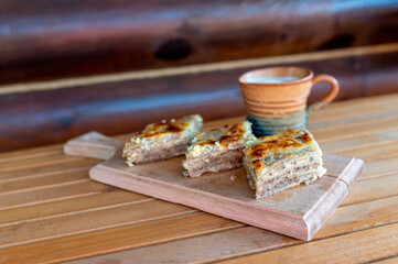 Delicious pieces of fresh baked homemade buckwheat pie and yogurt served on the wooden plate