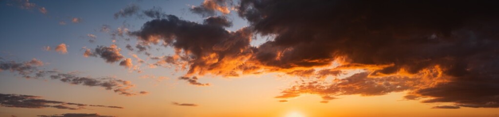 Summer sunset sky panorama with fleece colorful clouds. Evening dusk good weather natural high resolution background.