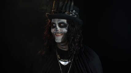 Creepy man with skeleton makeup. Guy turning his head and looking at camera, trying to scare
