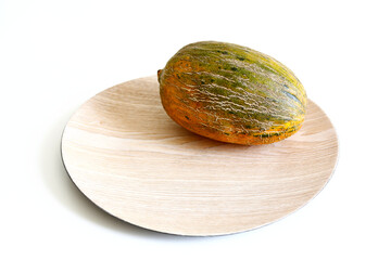 Fresh sugar melon on a wooden platter on a white background