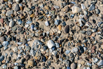 Beach texture with sand, stones, pebbles and shells.