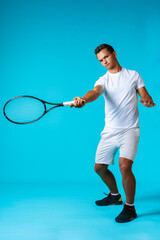 Full length studio portrait of a tennis player man on blue background
