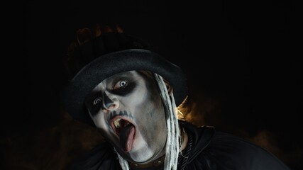 Fototapeta premium Sinister, crazy man with skeleton makeup. Guy making angry faces, shaking head, showing tongue