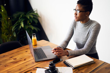 Pensive ethnic female entrepreneur contemplating over work issues