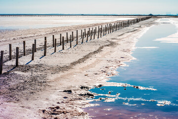 Wooden poles on the salt lake with rose water, Crimea