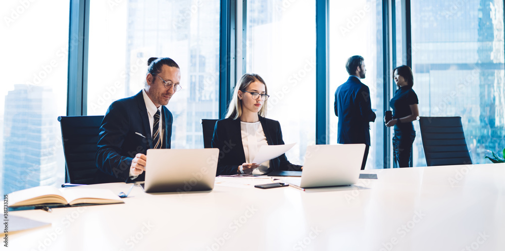 Poster skilled caucasian traders sitting at office desktop and checking mail search message with financial 