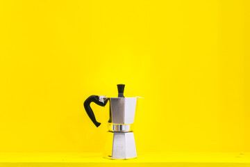Espreso moka pot isolated in yellow background. Designs of coffee makers concept.