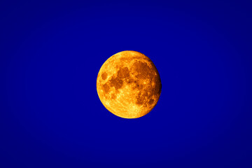 Full moon isolated on blue background. Close up Image.