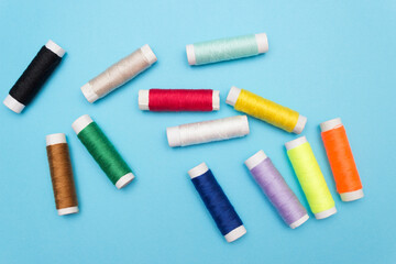 Colored sewing thread on a blue background