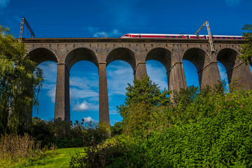 A view looking up at a train crossing the Digswell Viaduct near Welwyn Garden City, UK in the...