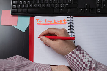 man makes  to-do list. Male hands on personal diary top view.Person writing on notebook