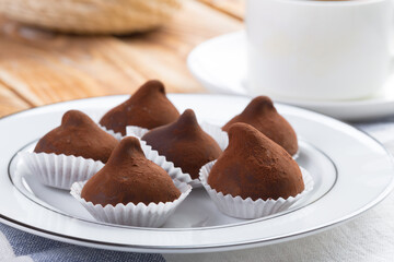 Chocolate truffles sweets in plate on wooden table