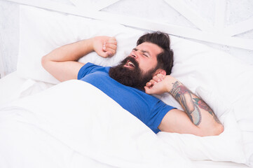 handsome mature male hipster in the morning yawning and stretching in bed, full of energy