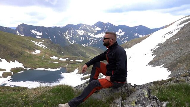 Man relax and admire beautiful view high in the mountains, slow motion
