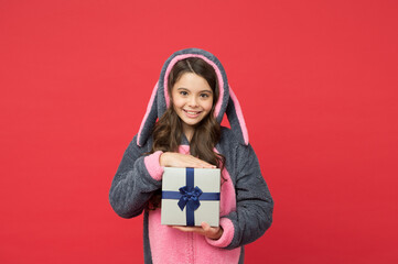 shopping gift for holiday. christmas or new year. cute kid in fluffy rabbit pajama hold present...