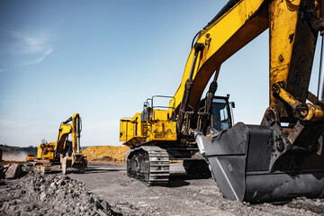 Excavator work loading of coal into Yellow mining truck. Open pit mine industry