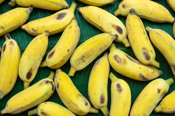 Flat lay layout of yellow bananas on a green banana leaf. Eco food