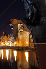 Night panorama of Old Town's waterfront in Gdansk. Medieval great crane Zuraw and s/s Soldek moored...