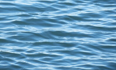 Natural light blue river water surface with soft waves as a background