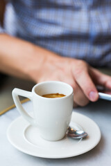 Businessman sitting in cafe, drinking morning coffee and using smartphone