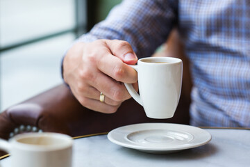 Businessman sitting in a cafe and drinking morning coffee