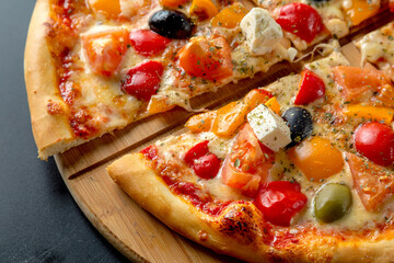 Greek pizza with olives, bell peppers, feta cheese and tomatoes.