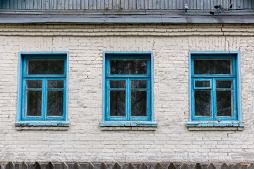 Three blue windows in a brick house