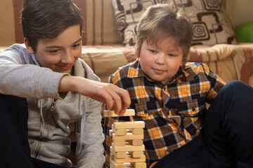Boy play Jenga game together. child playing at home intrerior